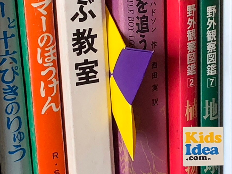 "Syuriken" of origami sandwiched between books on the bookshelf ©︎2023 kids-idea.com